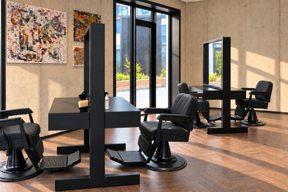 Men’s Studio soe ja valgusküllane salong: mustad juuksuritoolid, peeglid ja värvilised maalid
